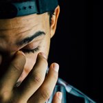 Парень в кепке чешет переносицу