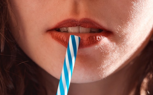 Коктейльная палочка прикасается к губе