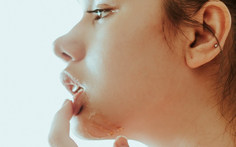 Девушка трогает нижнюю губу