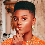 Женщина прикасается указательным пальцем к нижней губе