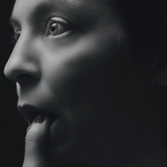 Женщина касается пальцем нижней губы