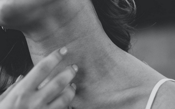 Женщина хочет почесать шею слева