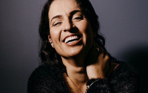 Женщина чешет левую сторону шеи и ключицу