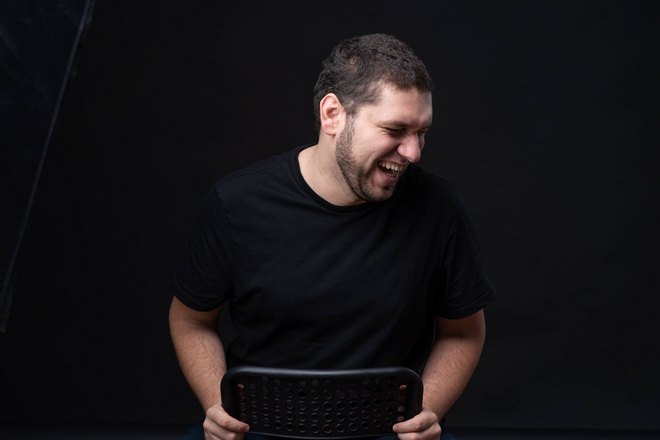 Мужчина чихает на стуле