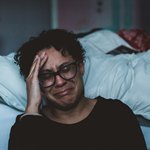 Плачущая женщина возле кровати