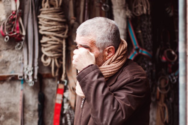 Мужчина чешет бровь левой рукой
