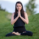 Женщина медитирует на траве