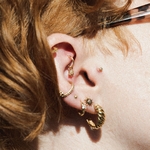 Женщина носит очки и колечки в ухе