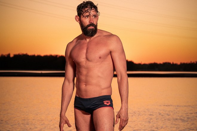 Мужчина в трусах с бородой на фоне заката