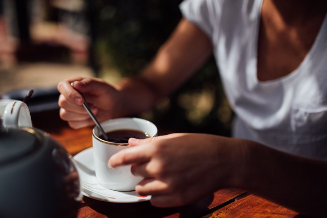 Кто-то держит чашку чая с ложкой