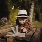 Мальчик читает книгу на столе