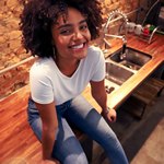 Девушка сидит на столе и улыбается