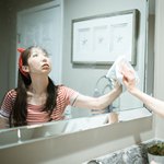 Девушка вытирает зеркало