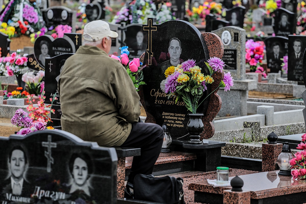 мужчина сидит возле памятника