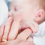 Ребенок держит взрослого за палец с кольцом