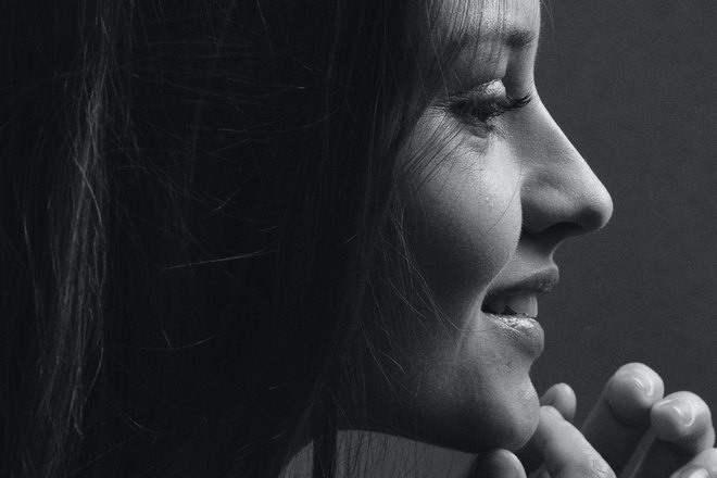 Девушка рассматривает родинку на подбородке