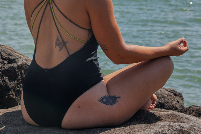 Женщина медитирует на побережье