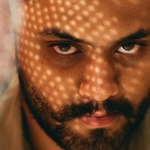 Мужчина с усами и родинкой возле правого глаза