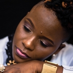 Задумчивая девушка с родинкой возле левой брови