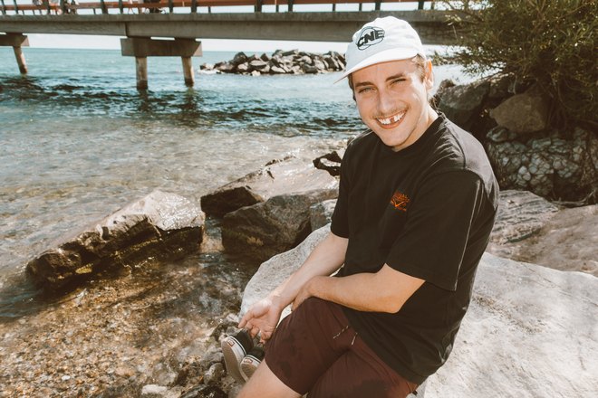 Парень в белой кепке возле водоема