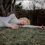 Светловолосый парень спит на траве