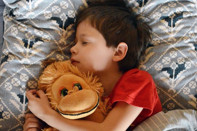 Ребенок спит с мягкой игрушкой