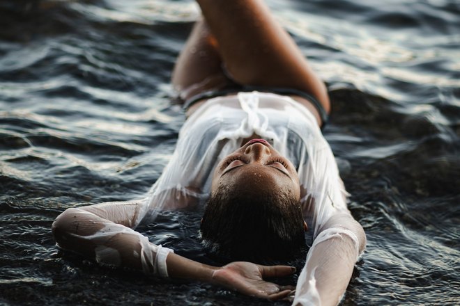 девушка лежит в море