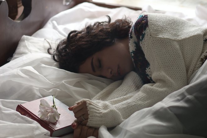 девушка спит возле книги