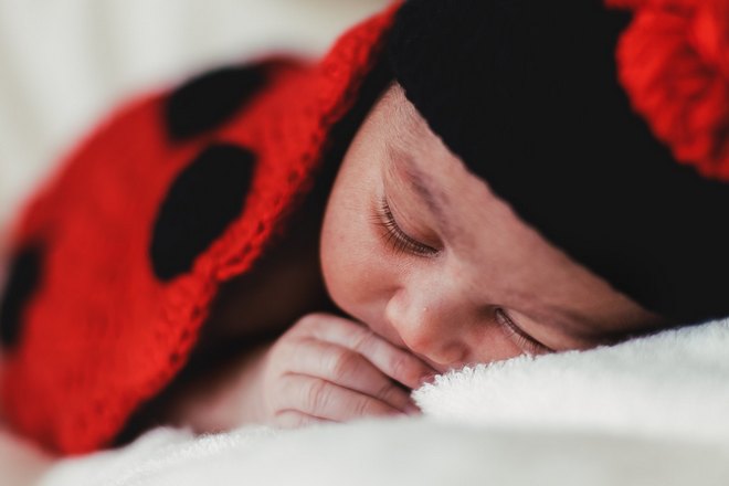 Спящий ребенок в красно-черной одежде