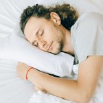 Спящий парень с красной нитью на запястье