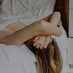 Девушка спит на краю кровати