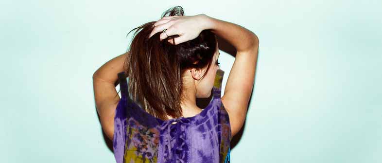 модель держит волосы в руке