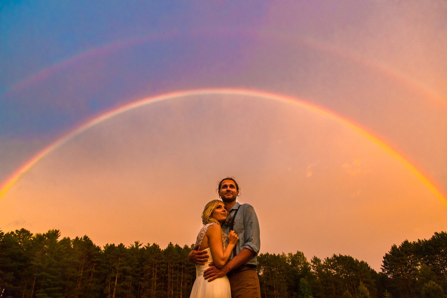 молодая пара обнимается на фоне леса