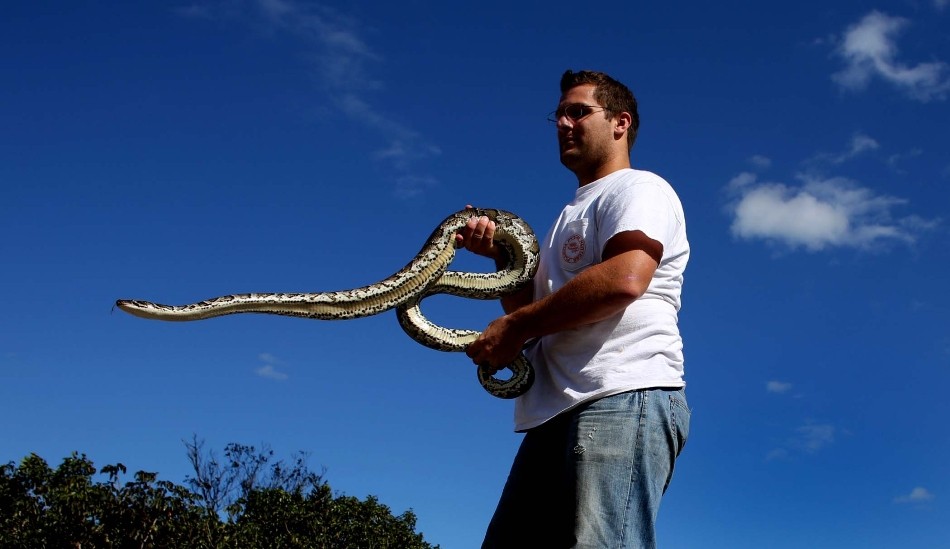 молодой человек со змеей на фоне голубого неба