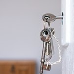 Ключ в замке белой двери