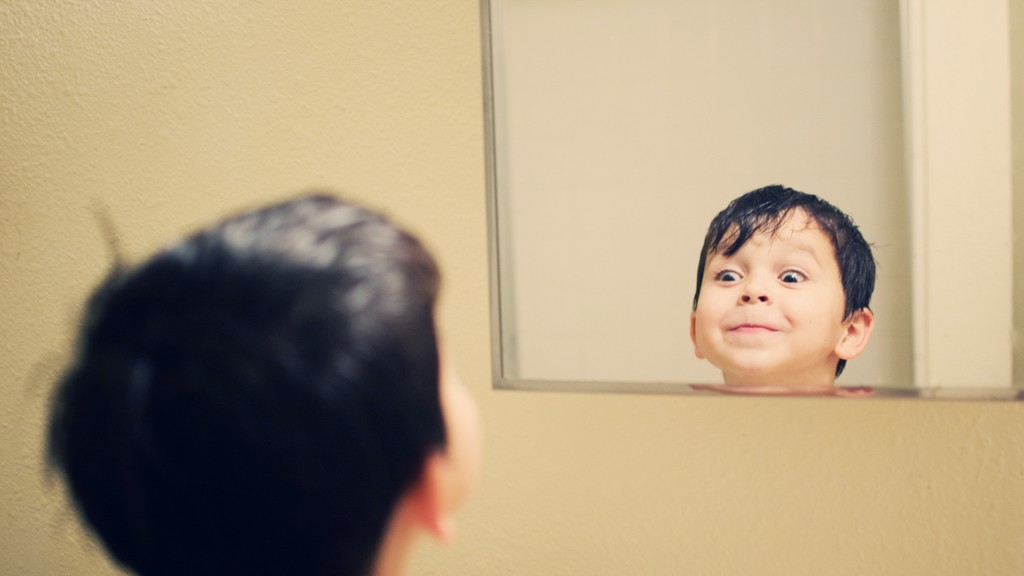 ребенок смотрит в зеркало