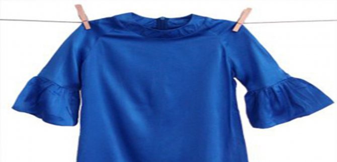 Синяя кофта висит на прищепках и сушится.