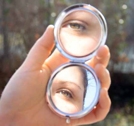 смотрит в зеркале