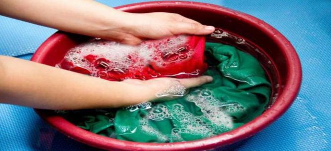 В тазике руками стирают вещи.