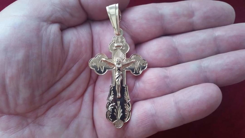 золотой крестик на ладони