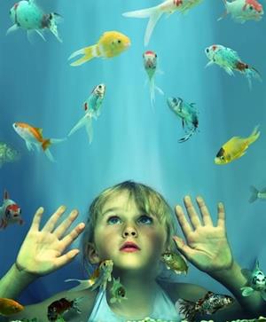 Девочка смотрит на рыбок
